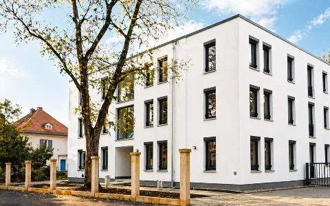 Modernes Wohngebäude mit großen dunklen Fensterrahmen und klarer Architektur in Dresden.